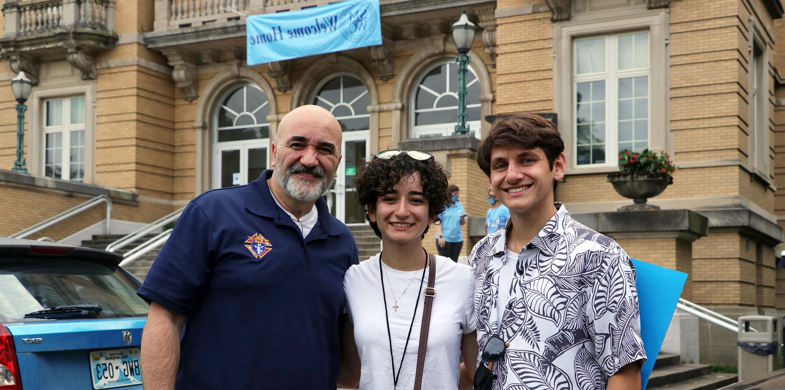 A student with her family poses in front of Le Fer